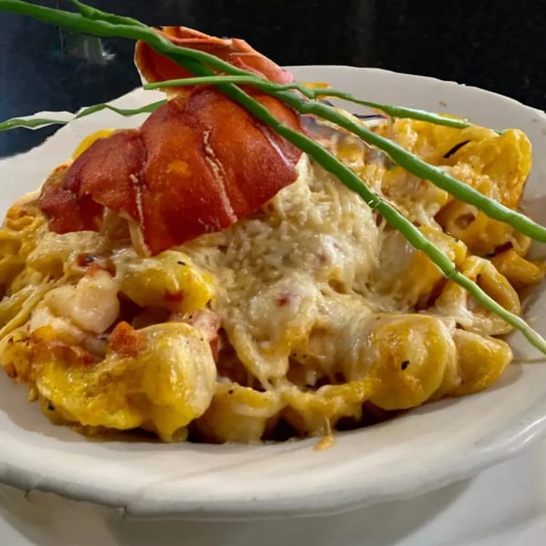 A close-up of The Original Railroad Seafood Station's lobster mac and cheese, garnished with chives.